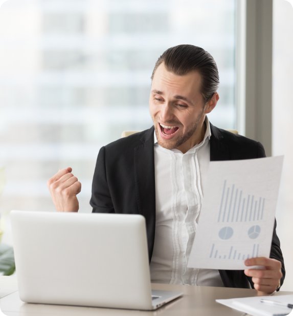 Man in a suit excitedly presenting a financial report with graphs.